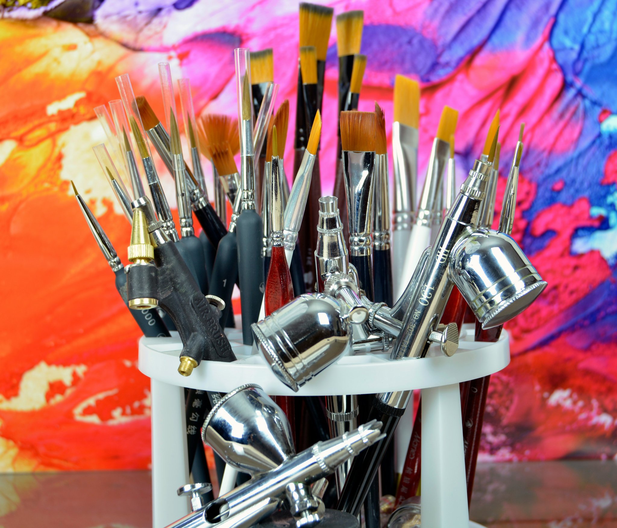A close-up shot of various nail art tools including brushes, dotting pens, and stencils.