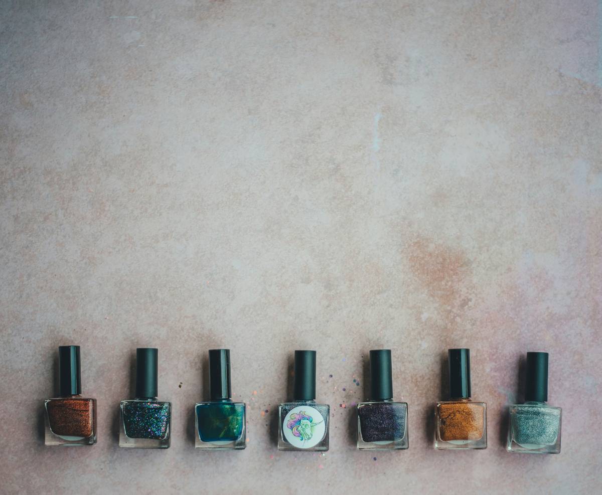 A failed DIY nail art attempt showing uneven lines and blobs