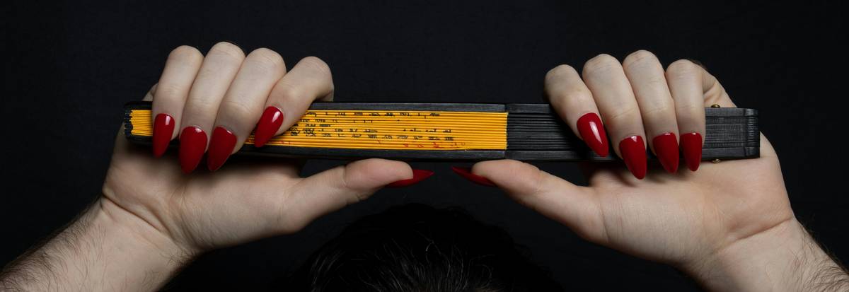 Close-up shot of Sarah's colorful abstract nail art featuring bold yellow and blue swirls.