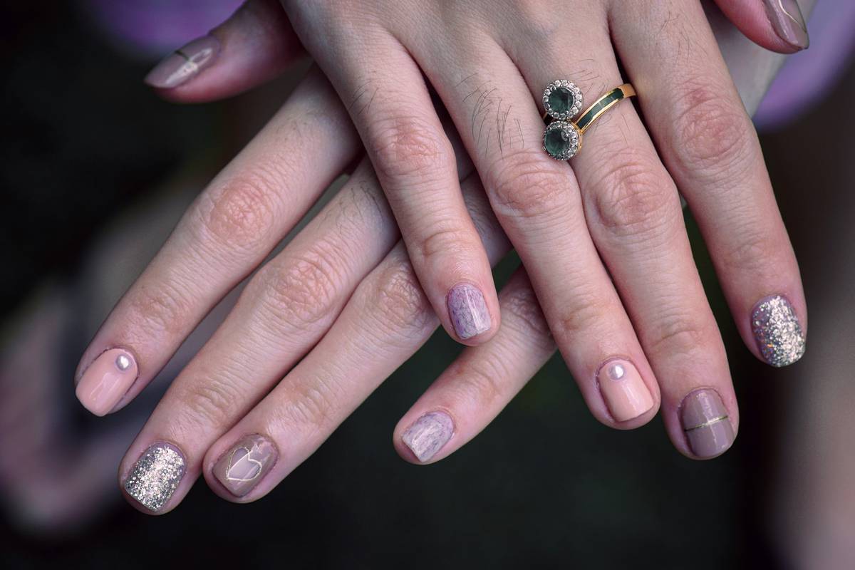 Nails adorned with exquisite dot-work and intricate patterns.