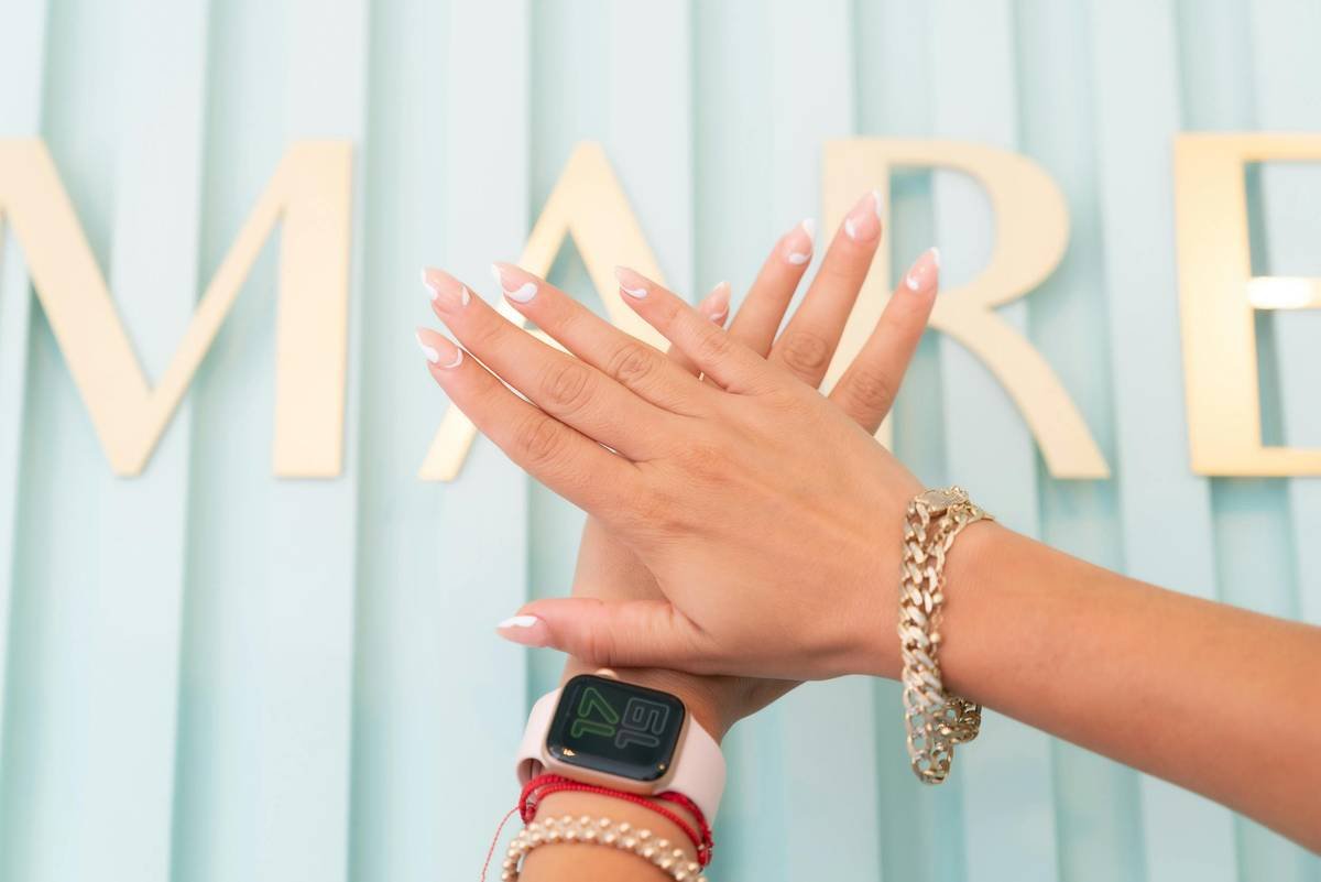 Close-up of a stainless steel nail design chain dipped in red polish, showing individual links ready for stamping