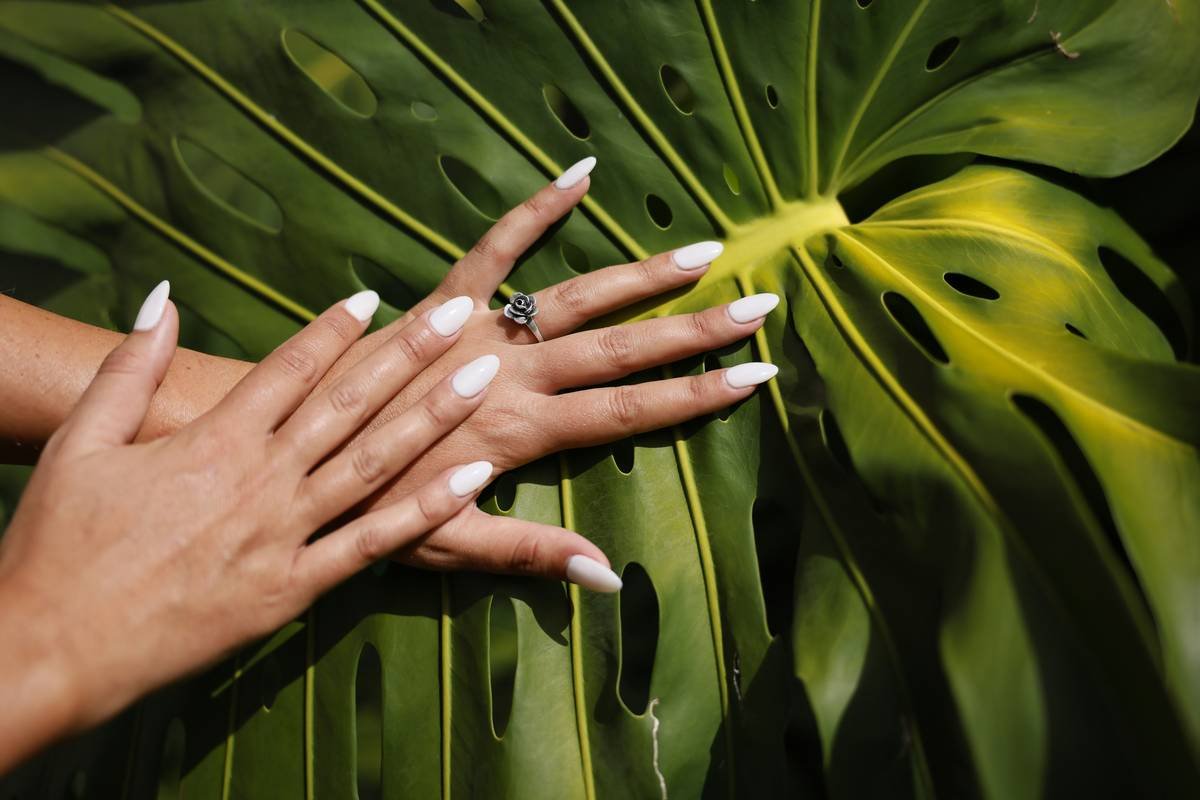 Silver tone rose ring and nice manicure with white acrylic nails.